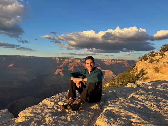The diarist sitting on pale rock with the Grand Canyon behind him
