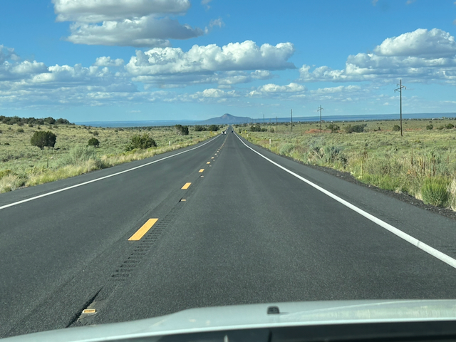 A straight highway crossing open Arizona country toward a distant peak